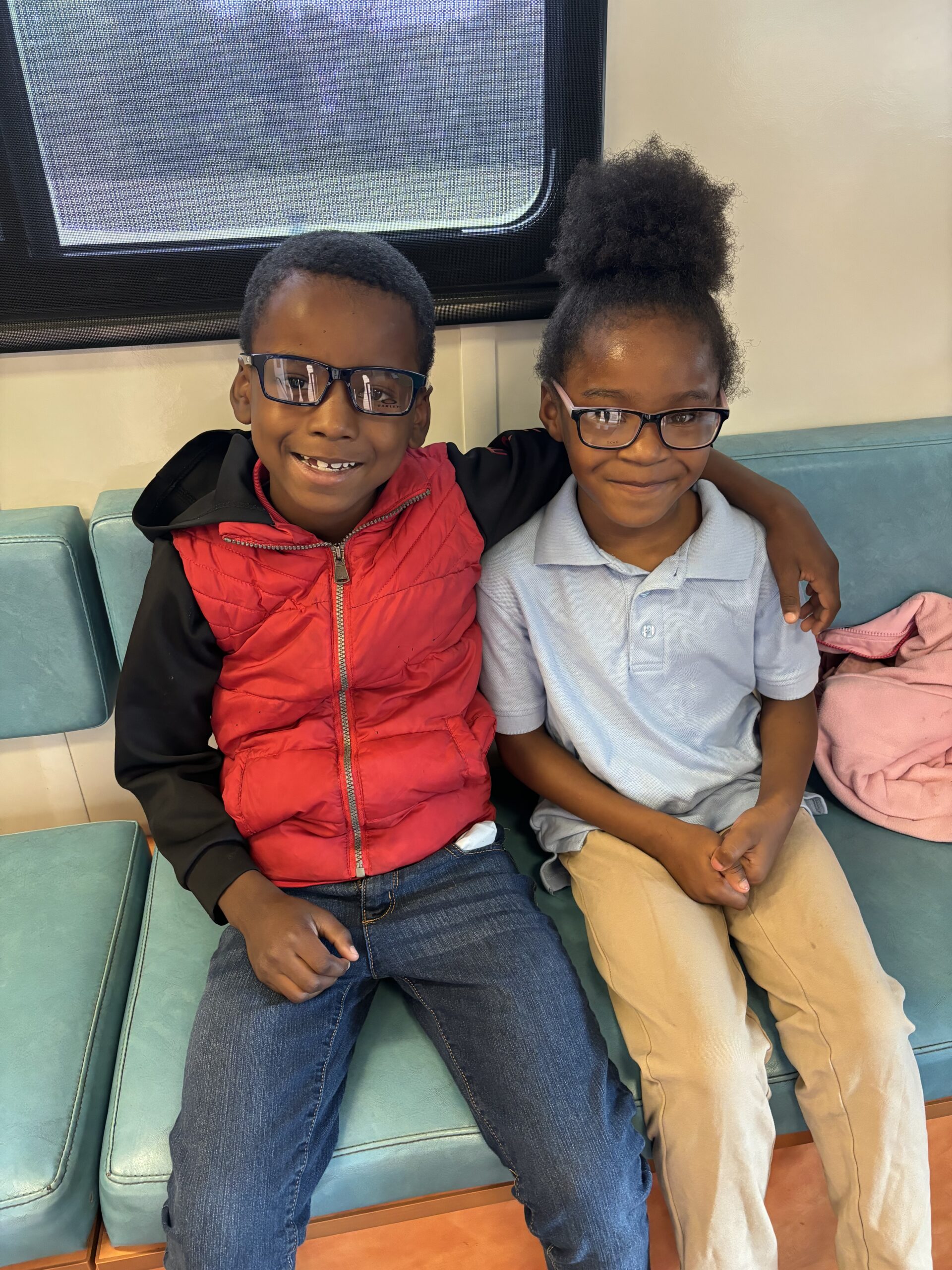 Two smiling students wearing their new glasses